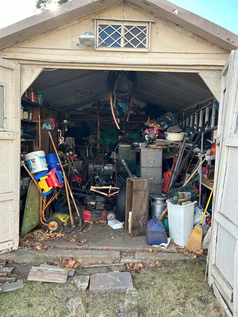 Backyard shed packed with tools, equipment, and clutter before cleanout in Queens